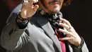 Aktor Johnny Depp memakai kacamata hitam dan syal saat menghadiri sidang pencemaran nama baik di Pengadilan Tinggi, London, Inggris, Selasa (21/7/2020). Johnny Depp menggugat tabloid The Sun atas artikel yang menyebut dirinya telah melakukan kekerasan terhadap sang istri. (AP Photo/Alastair Grant)