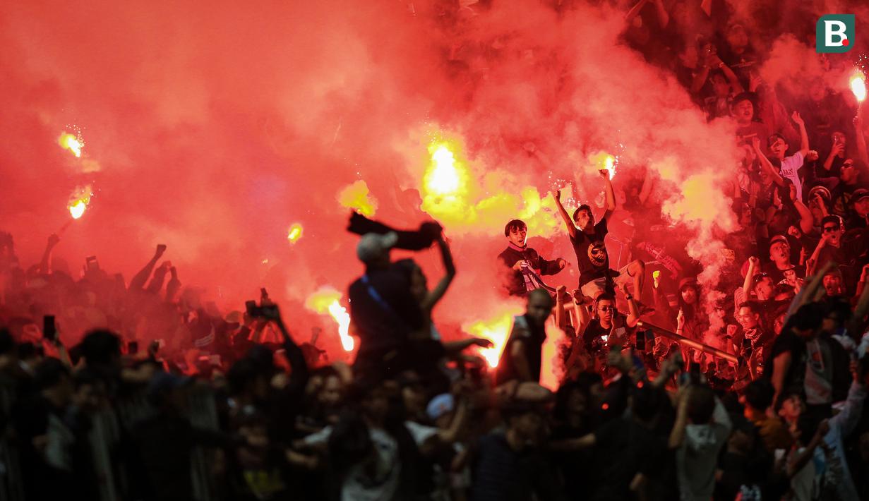 Usai menyanyikan laga tersebut, kedua kelompok suporter saling memberikan tepuk tangan meriah. (Bola.com/Bagaskara Lazuardi)