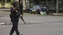 Polisi memeriksa lokasi di dekat sebuah gereja setelah ledakan di Makassarr (28/3/2021).   Polisi menduga ledakan terjadi akibat bom bunuh diri. (AFP/Indra Abriyanto)