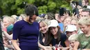 Duchess of Sussex, Meghan Markle menyapa anak kecil saat berjalan di Taman Pemerintah Rotorua, Selandia Baru, Rabu (31/10). Meghan dan Pangeran Harry sedang dalam tur tiga minggu di Australia, Selandia Baru, Tonga, dan Fiji. (Michael Bradley/Pool/AFP)