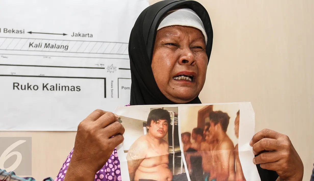 Ibunda korban salah tangkap, Nani menunjukan foto korban salah tangkap bernama didit saat konferensi pers di Gedung LBH, Jakarta, (3/1). Keluarga korban meminta kepada pihak Kepolisian untuk membebaskan terdakwa Didit. (Liputan6.com/Faizal Fanani)