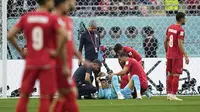 Kiper Timnas Iran, Alireza Beiranvand mengalami cedera usai berbenturan dengan rekannya Majid Hosseini dalam laga matchday pertama Grup B Piala Dunia 2022 menghadapi Timnas Inggris di Khalifa International Stadium, Doha, Qatar, Senin (21/11/2022) malam WIB. (AP/Abbie Parr)