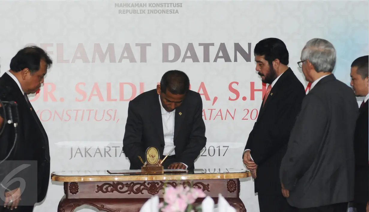 Saldi Isra (tengah) menandatangani pakta integritas saat penyambutan di Jakarta, Selasa (11/4). Saldi Isra menjadi Hakim MK menggantikan Patrialis Akbar yang tersandung kasus dugaan penyuapan. (Liputan6.com/Helmi Fithriansyah)