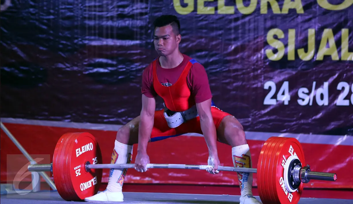 Lifter Lampung, Viky Aryanto saat akan mengangkat beban seberat 291kg di kelas 66 kg putra PON XIX di GOR Sabilulungan, Kab Bandung, Minggu (25/9). Viky merebut emas di kelas 66 kg dengan total angkatan 798 kg. (Liputan6.com/Helmi Fithriansyah)