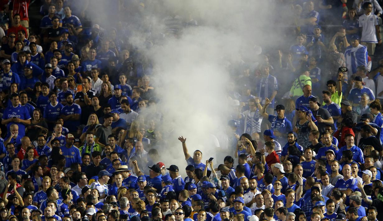 Aksi suporter Chelsea melepaskan bom asap saat timnya melawan Liverpool pada laga pra musim International Champions Cup di Rose Bowl, Pasadena, California, (28/7/2016) pagi WIB. (Reuters/Mike Blake)