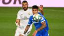 Penyerang Real Madrid, Karim Benzema, berebut bola dengan bek Getafe, Mathias Olivera, pada laga lanjutan La Liga pekan ke-33 di Stadion Alfredo Di Stefano, Jumat (3/7/2020) dini hari WIB. Real Madrid menang 1-0 atas Getafe. (AFP/Gabriel Bouys)