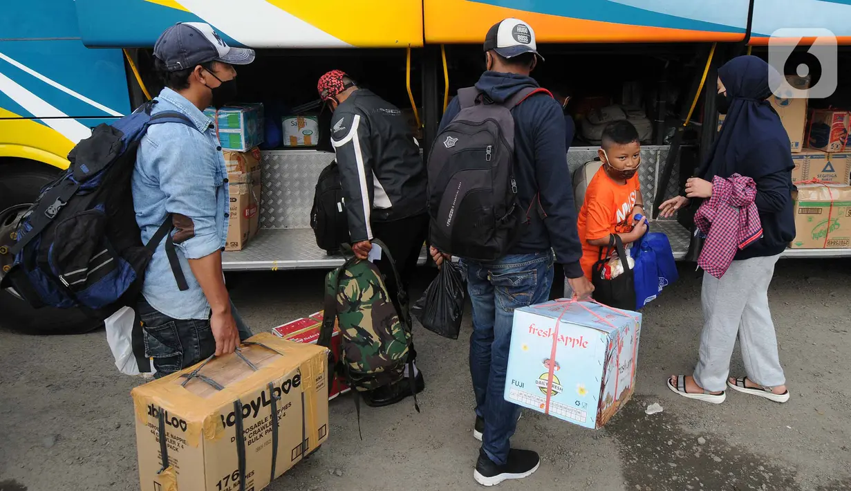 Pemudik memasukkan bawaan ke dalam bagasi bus di terminal bayangan di Pasar Jumat, Jakarta, Rabu (5/5/2021). Jelang pemberlakuan larangan mudik 2021 pada esok hari, sejumlah terminal bayangan di wilayah Jabodetabek dipadati para pemudik tujuan Pulau Jawa dan Sumatera. (merdeka.com/Arie Basuki)