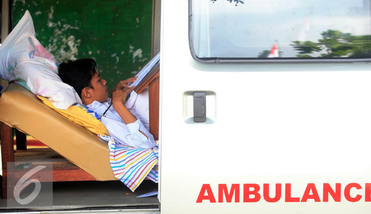 Seorang siswa SMP N 2 Pakem ,Fitrian (14) sedang mengerjakan soal Ujian Nasional di halaman SMP N 2 Pakem, Sleman, (10/5). Akibat kecelakaan,Fitrian terpaksa melaksanakan UN di dalam mobil ambulans . (Liputan6.com/Boy Harjanto)