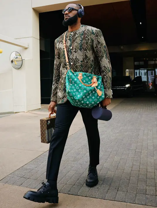 Outfit jalanan kece ala Lebron James. Ia memadukan jaket motif abstraknya dengan long pants hitam dan tas LV Speedy P9 warna hijau. [Dok/Louis Vuitton]