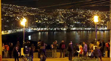 Warga berdiri dan melihat ke laut di Bukit Cerro Barron di kota Valpraiso usai gempa 8,3 SR, Chile, Rabu (16/9).  Menurut laporan dari otoritas setempat, gempa itu berpotensi memicu tsunami yang akan melanda Chile dan Peru.  (REUTERS/Rodrigo Garrido)