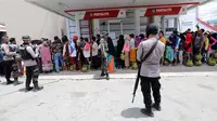 Warga antre membeli tabung gas 3 kg saat operasi pasar elpiji di SPBU Ki Hajar Dewantara di Palu, Sulawesi Tengah, Senin (8/10). Pertamina melakukan operasi pasar elpiji pascagempa dan tsunami Palu.  (Liputan6.com/Fery Pradolo)