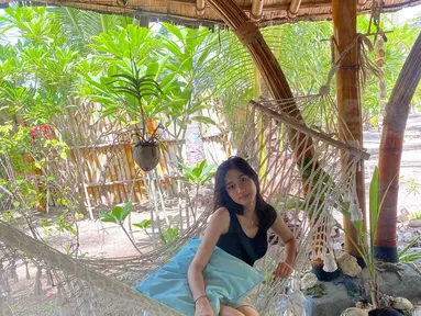 Keisya Levronka tengah asyik bersantai di atas hammock ditemani seekor anjing. (Foto: Instagram/@keisyalevronka)