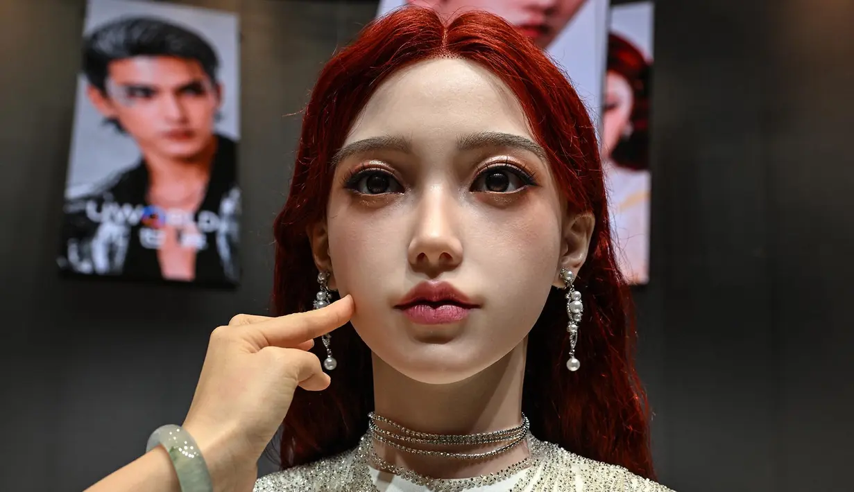 Seorang wanita menyentuh wajah robot humanoid selama peluncuran robot humanoid U1 yang diproduksi oleh UWORLD, sebuah merek di bawah UBTECH Robotics, di Shenzhen, provinsi Guangdong, Tiongkok, Selasa (30/06/2026). (AFP/ Adek Berry)