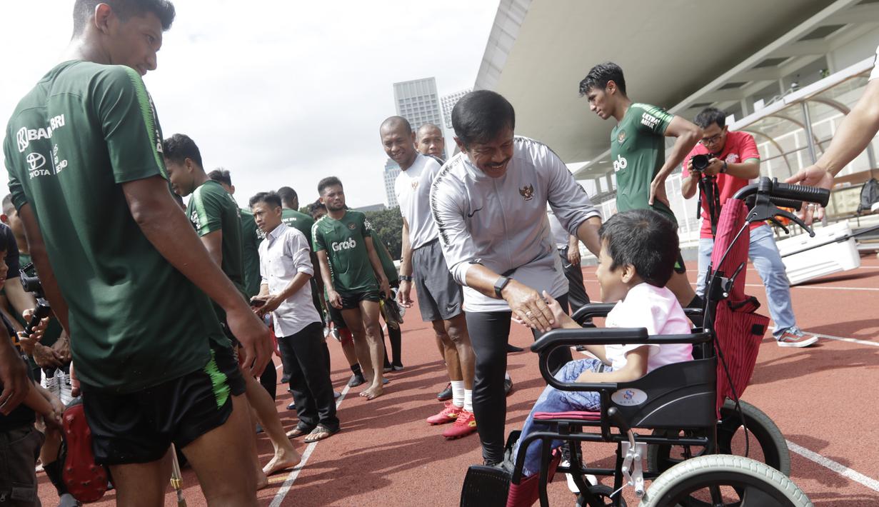 Pelatih Timnas Indonesia U-23, Indra Sjafri, menyapa seorang anak yang datang ke Stadion Madya, Jakarta, Rabu (13/3). Sejumlah anak dari Yayasan Rumah Harapan Indonesia datang menemui Timnas U-23 (Bola.com/Vitalis Yogi Trisna)