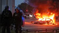 Sebuah mobil terbakar saat para pendukung Paris Saint-Germain (PSG) merayakan kemenangan tim mereka setelah final Liga Champions melawan Arsenal di Budapest, di Paris, Prancis, Sabtu (30/5/2026). (Dok. AP Photo/Thomas Padilla)