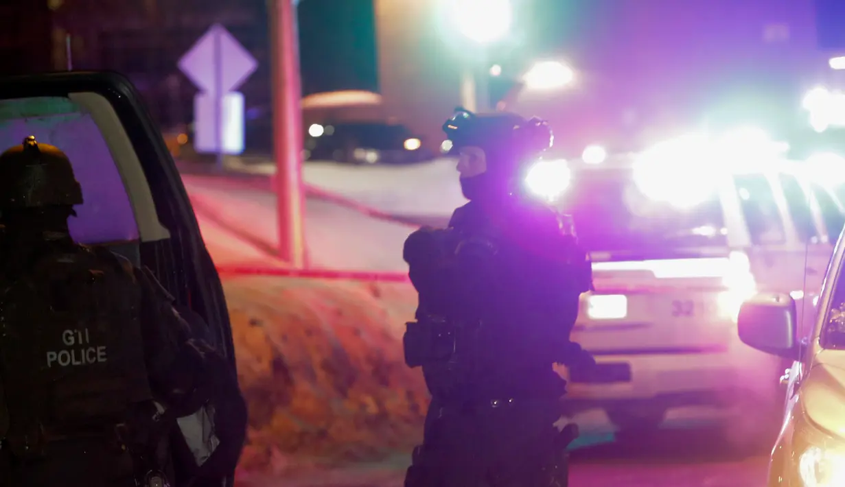 Petugas berjaga di dekat sebuah masjid usai penembakan di Quebec City, Kanada (29/1). Setidaknya lima orang dilaporkan tewas dalam kejadian penembakan tersebut dan terdapat pula beberapa orang yang menderita luka. (The Canadian Press/Francis Vachon)