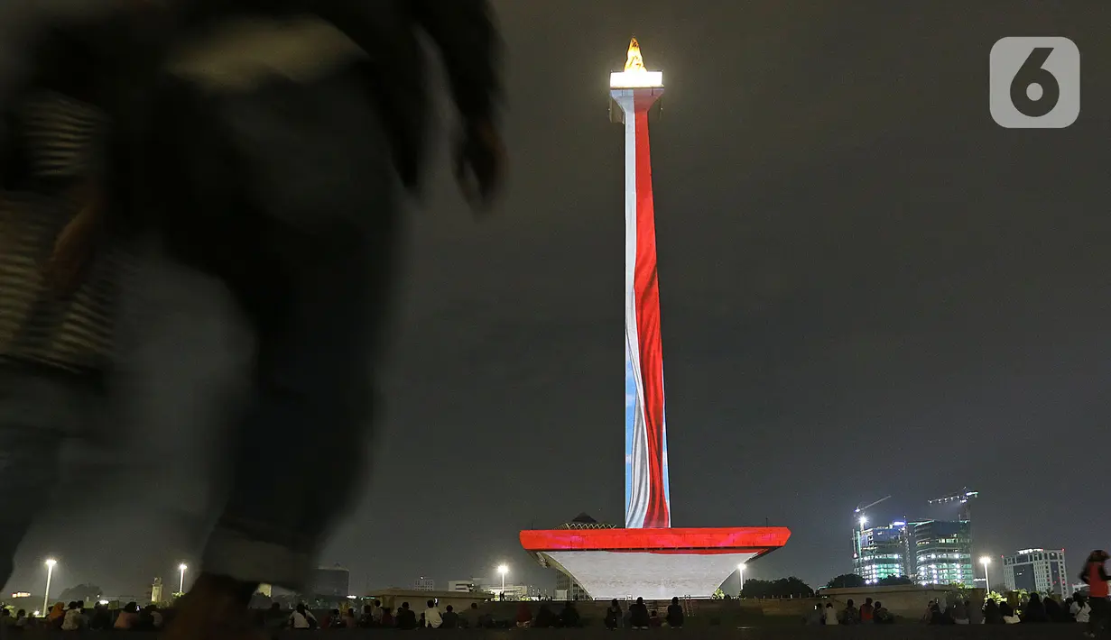Suasana saat warga menyaksikan pertunjukan video mapping di Monumen Nasional (Monas), Jakarta, Minggu (22/12/2019). Acara ini berlangsung di pelataran barat Tugu Monas pada 22-31 Desember 2019. (Liputan6.com/Herman Zakharia)