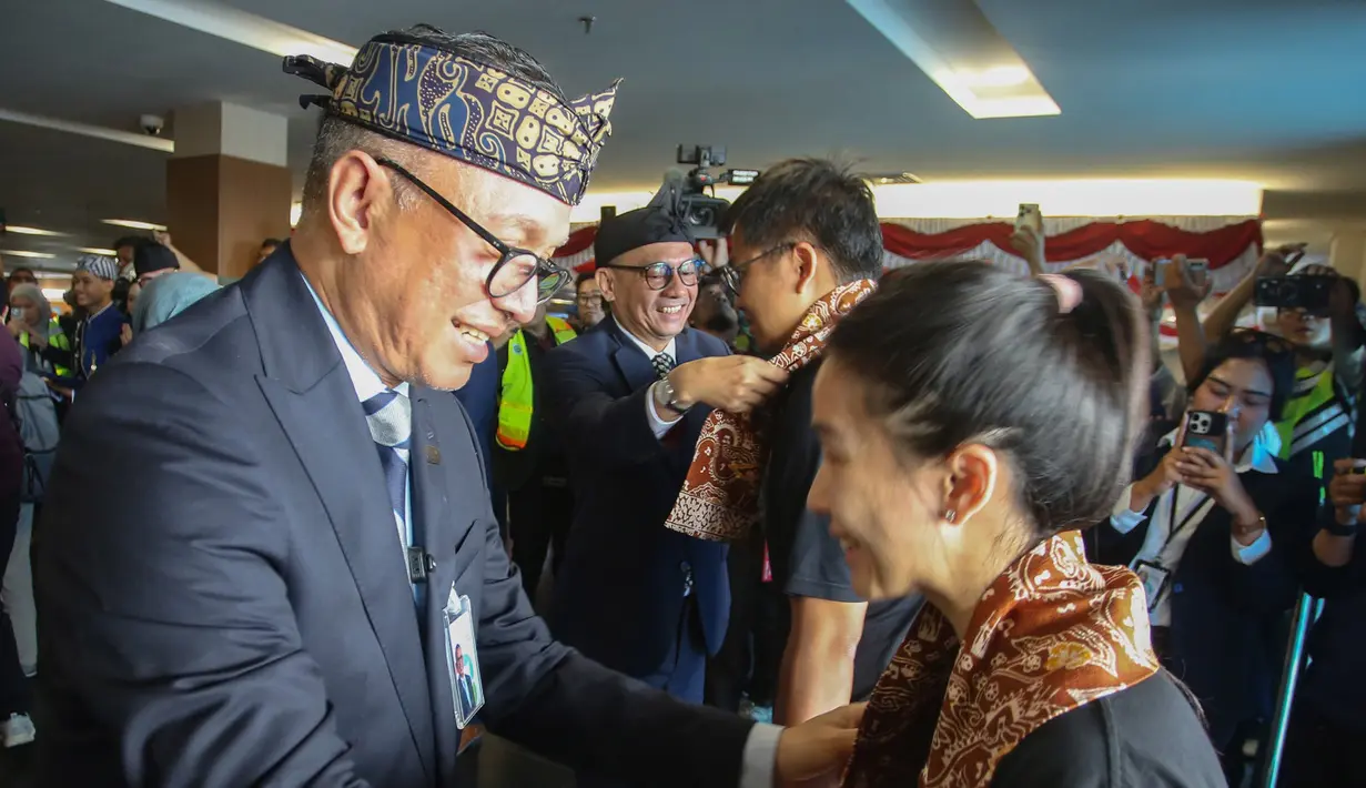 Direktur Utama PT Angkasa Pura Indonesia (Persero) Muhammad Rizal Pahlevi mengalungkan kain kepada penumpang yang baru tiba di Bandara Husein Sastranegara, Bandung, Jawa Barat, Jumat 14 Agustus 2026. (Istimewa)