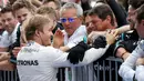 Nico Rosberg bersama tim seusai kemenangannya dalam seri ke-17 Formula One (F1) GP Jepang, Minggu (9/10). Kemenangan Rosberg juga membuat tim Mercedes merebut gelar juara dunia konstruktor musim ini. (REUTERS/Toru Hanai)