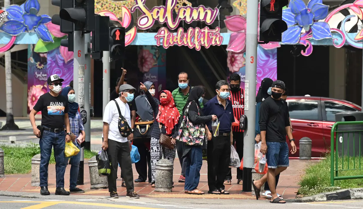 <p>Sejumlah orang mengenakan masker untuk mengantisipasi terpapar virus corona COVID-19 di Pasar Geylang Serai, Singapura, Kamis (21/5/2020). Hari Raya Idul Fitri tahun ini akan dirayakan di tengah pandemi virus corona COVID-19. (Roslan RAHMAN/AFP)</p>