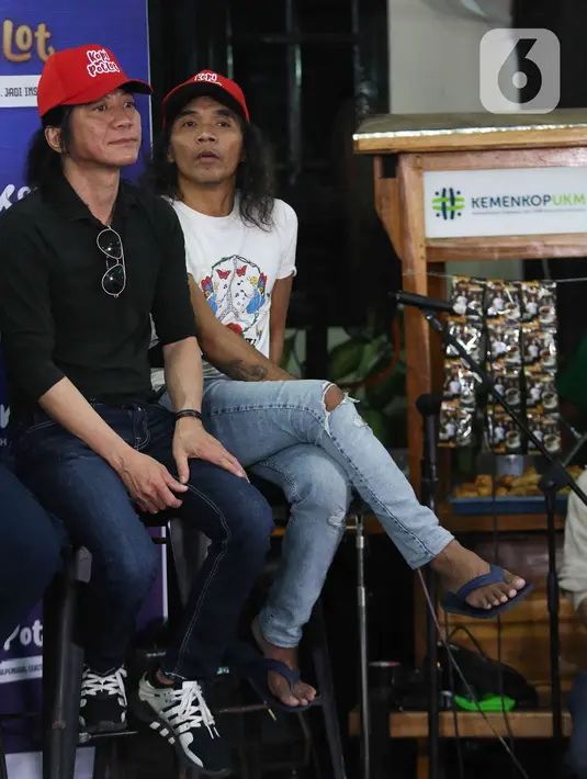 Vokalis grup band Slank Kaka (kanan) bersama gitaris Abdee saat peluncuran Slankops di Basecamp Slank, Jakarta, Selasa (19/7/2022). Slankops diluncurkan sebagai bentuk kepedulian dan dedikasi personelnya untuk memberdayakan generasi muda yang utamanya para Slanker dan wadah berproses menjadi wirausaha mandiri serta tangguh. (Liputan6.com/Herman Zakharia)