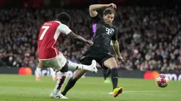 Gelandang Arsenal, Bukayo Saka melepaskan tendangan yang berbuah gol pertama timnya ke gawang Bayern Munchen pada laga leg pertama babak perempatfinal Liga Champions 2023/2024 di Emirates Stadium, London, Selasa (9/4/2024) malam. (AP Photo/Frank Augstein)