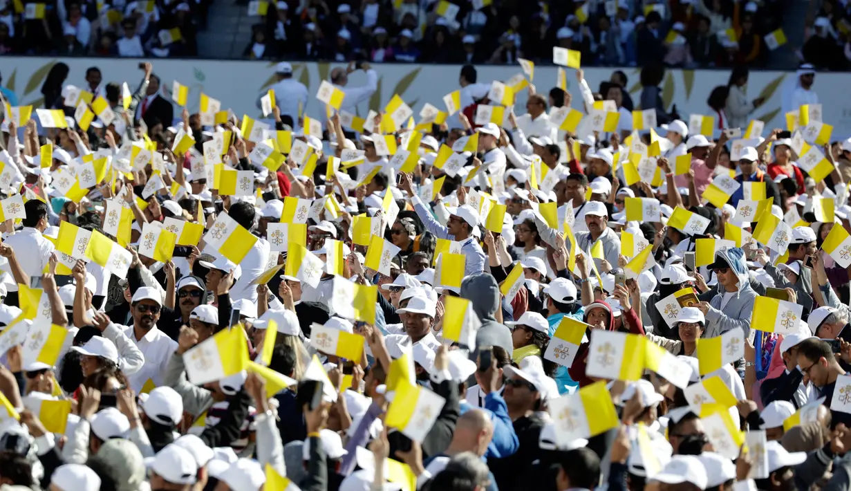 Bendera Vatikan dikibarkan warga ketika mereka menunggu kedatangan Paus Fransiskus di Stadion Zayed Sports City di Abu Dhabi, Uni Emirat Arab, Selasa (5/2). (AP Photo/Kamran Jebreili)