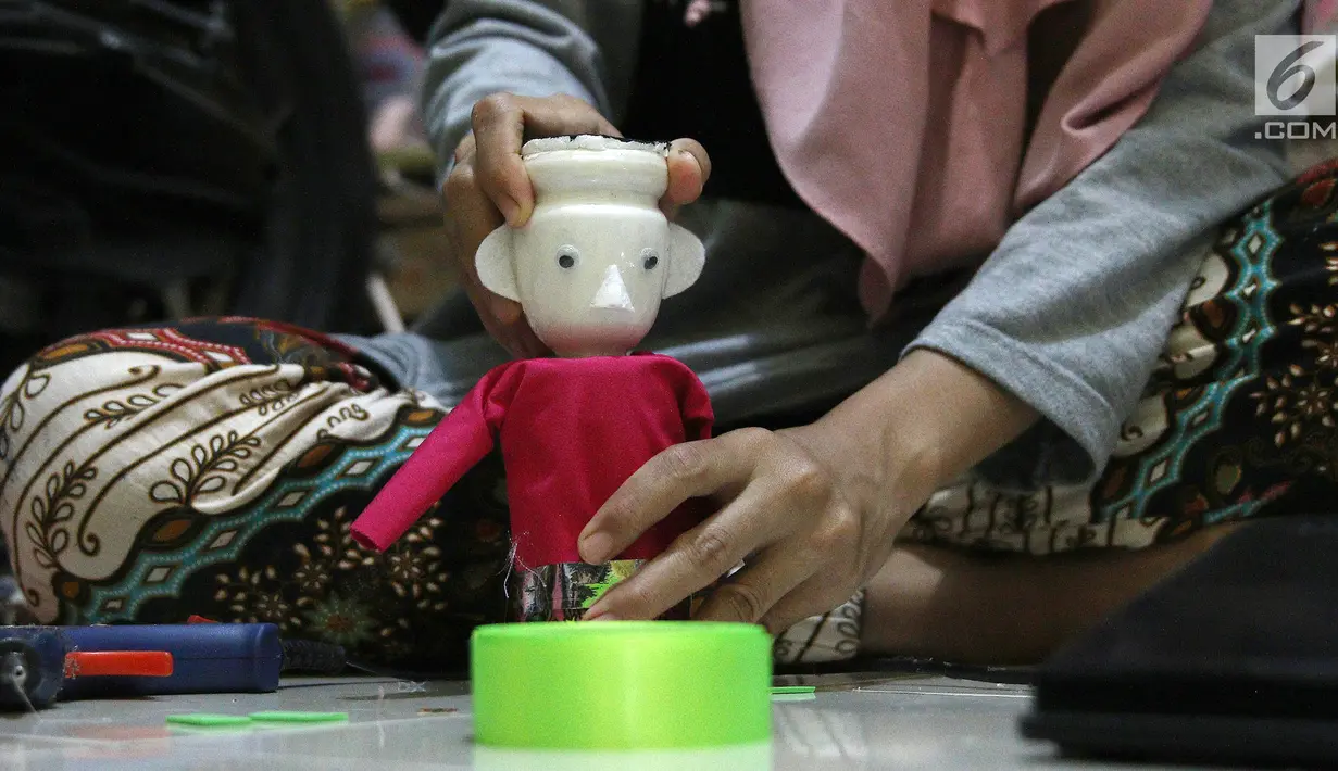 Perajin, membuat miniatur ondel-ondel dari botol plastik di rumah produksi Kramat Jati, Jakarta, Rabu (28/11). Miniatur yang terbuat dari plastik diproduksi 50-80 buah dengan omset 5-8 Juta perbulan. (Liputan6.com/Herman Zakharia)