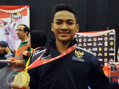 Ahmad Zigi Zaresta memamerkan medali yang diperoleh di nomor Junior Kata Male di WKF World Junior, Cadet and U-21 Championship 2015 di ICE Serpong, Banten, Kamis (12/11/2015). Zigi menyumbang emas pertama bagi Indonesia. (Liputan6.com/Helmi Fithriansyah)