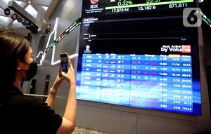 Karyawan memfoto layar pergerakan IHSG, Jakarta, Rabu (3/8/2022). Indeks Harga Saham Gabungan (IHSG) pada perdagangan di Bursa Efek Indonesia, Rabu (3/08/2022), ditutup di level 7046,63. IHSG menguat 58,47 poin atau 0,0084 persen dari penutupan perdagangan sehari sebelumnya. (Liputan6.com/Angga Yuniar)