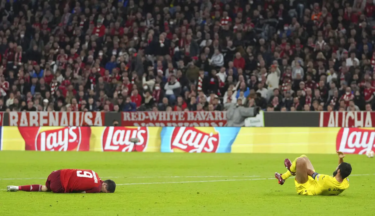 Pemain Bayern Munchen Robert Lewandowski (kiri) meringis kesakitan usai berebut bola dengan pemain Villarreal Raul Albiol (kanan) pada pertandingan leg kedua perempat final Liga Champions di Allianz Arena, Munich, Jerman, 12 April 2022. Pertandingan berakhir imbang 1-1. (AP Photo/Matthias Schrader)