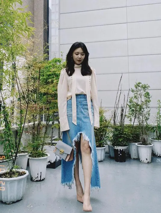 Kombinasi blouse dengan denim asymmetric denim skirt warna biru muda juga tak kalah menarik untuk outfit hangout (Instagram/sooyoungchoi).