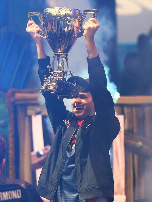 Remaja AS, Kyle Giersdorf alias Bugha merayakan kemenangannya pada turnamen game Piala Dunia Fornite kategori tunggal di Arthur Ashe Stadium, New York, Minggu (28/7/2019). Remaja 16 tahun ini membawa pulang hadiah senilai 3 juta dollar AS atau setara Rp 42 miliar. (Mike Stobe/Getty Images/AFP)