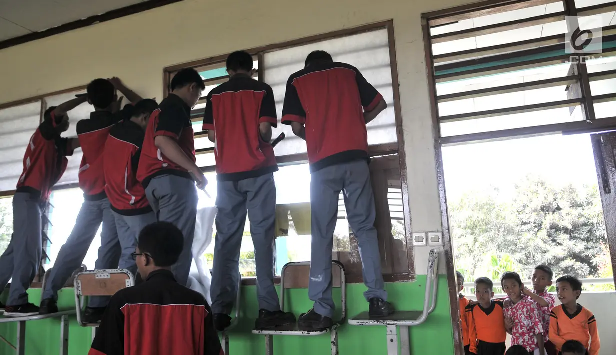 Siswa SMK Negeri 4 Jakarta Utara memasang kipas angin dan penyaring udara di SD Negeri Cilincing 07 Pagi, Jakarta, Kamis (19/9/2019). Instalasi dibuat sebagai kepedulian terhadap siswa SD setempat yang terdampak polusi asap pabrik pembuatan arang serta peleburan aluminium. (merdeka.com/IqbalNugroho)