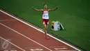 Atlet Indonesia, Rini Budiarti mengangkat tangan jelang finis lari halang rintang 3.000 meter SEA Games ke-28 di National Stadium, Singapura, (12/6/2015). Rini finish pertama dengan catatan waktu 10 menit 20,40 detik. (Liputan6.com/Helmi Fithriansyah)