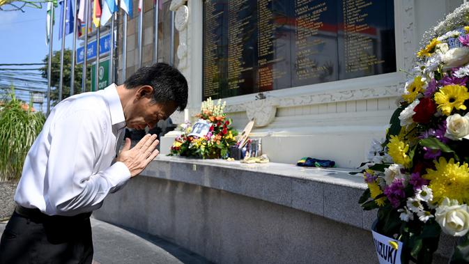 Pejabat konsulat Jepang berdoa di Monumen Bom Bali, Kuta, dekat Denpasar pada Sabtu (12/10/2019). MeMperingati 18 tahun peristiwa bom Bali yang terjadi pada 12 Oktober 2002, wisatawan dan kerabat korban mengunjungi tugu peringatan untuk berdoa dan tabur bunga. (SONNY TUMBELAKA / AFP)