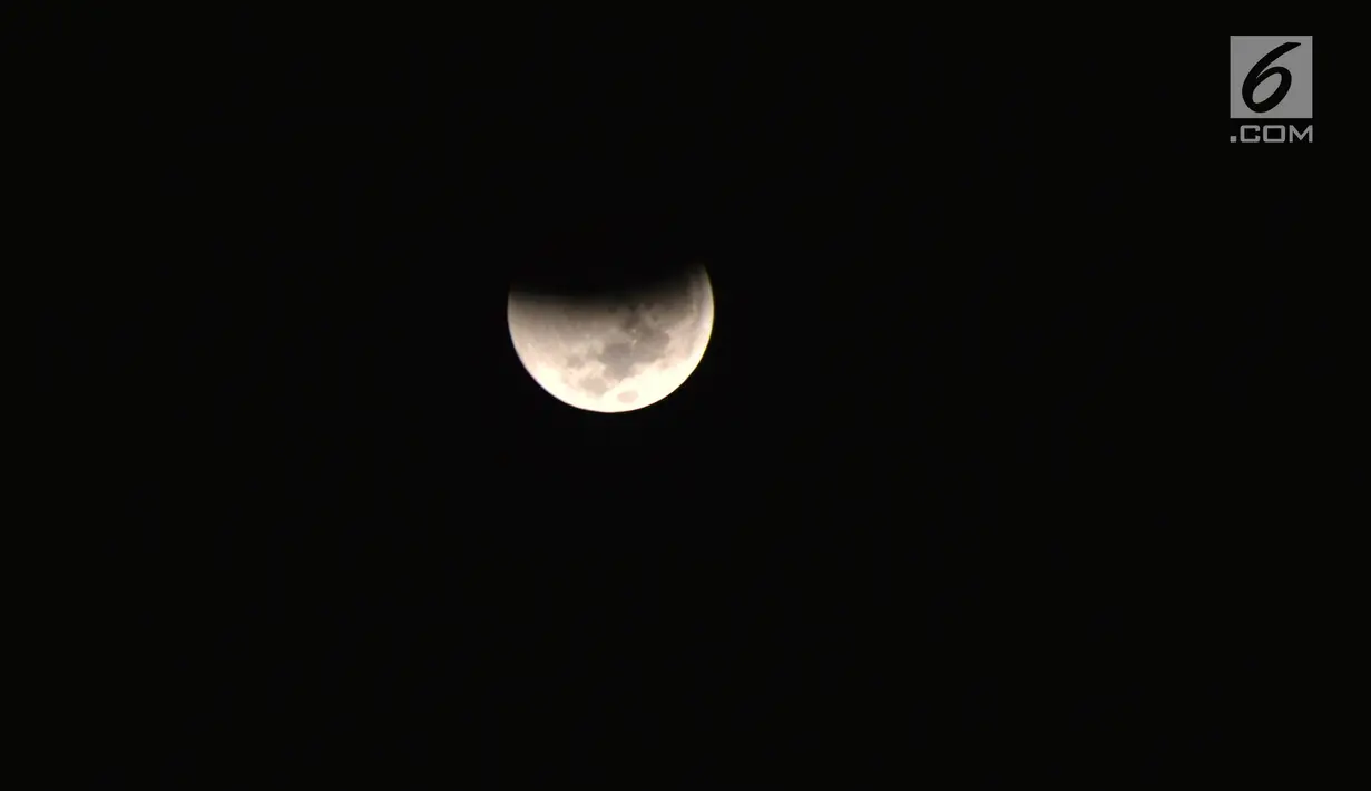Gerhana bulan total terlihat di kota Semarang, Sabtu (28/7) dini hari. Gerhana bulan total tahun ini merupakan fenomena langka karena terjadi selama 1 jam 43 menit atau merupakan gerhana terlama yang terjadi di abad ini. (Liputan6.com/Gholib)