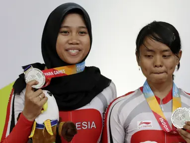 Pebalap sepeda Indonesia, Sri Sugiyanti dan Ni'mal Maghfiroh, saat pembagian medali pada Asian Para Games di Velodrome, Jakarta, Kamis (11/10/2018). Pasangan ini meraih medali perak di nomor trek Individual Pursuit B putri. (Bola.com/M Iqbal Ichsan)