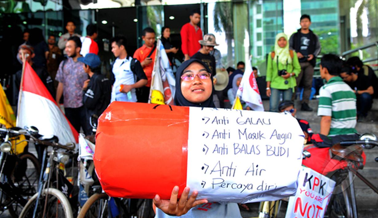 Seorang perempuan saat mengikuti aksi di depan Gedung Komisi Pemberantasan Korupsi (KPK), Jakarta, Senin (16/02/15).  Para pelajar mengayuh sepeda ontel selama 13 hari dari  Jember menuju Jakarta untuk mendukung KPK. (Liputan6.com/Faisal R Syam)
