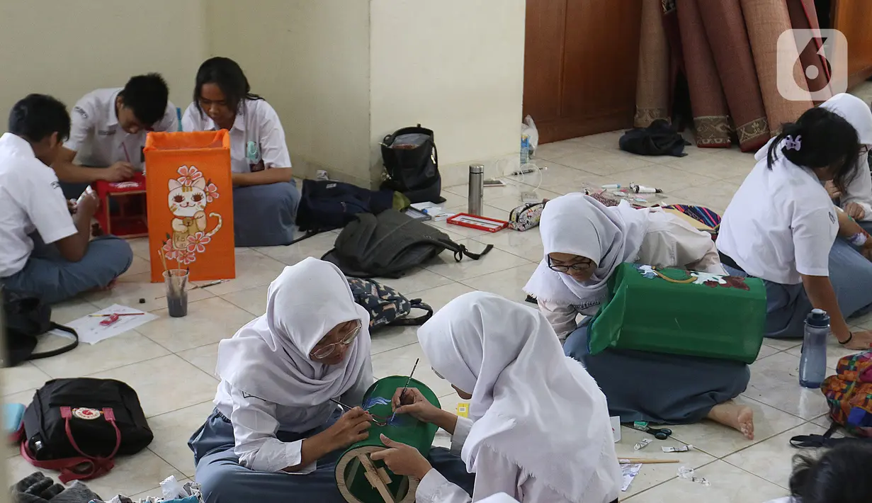 Siswa siswi sedang membuat lukisan bernuansa imlek menggunakan media lampion di SMA Negri 39 Jakarta, Selasa (21/1/2020). Kerajinan lukisan tersebut dibuat oleh siswa untuk menyambut hari imlek 2571 yang jatuh pada Sabtu (25/1) 2020. (Liputan6.com/Herman Zakharia)