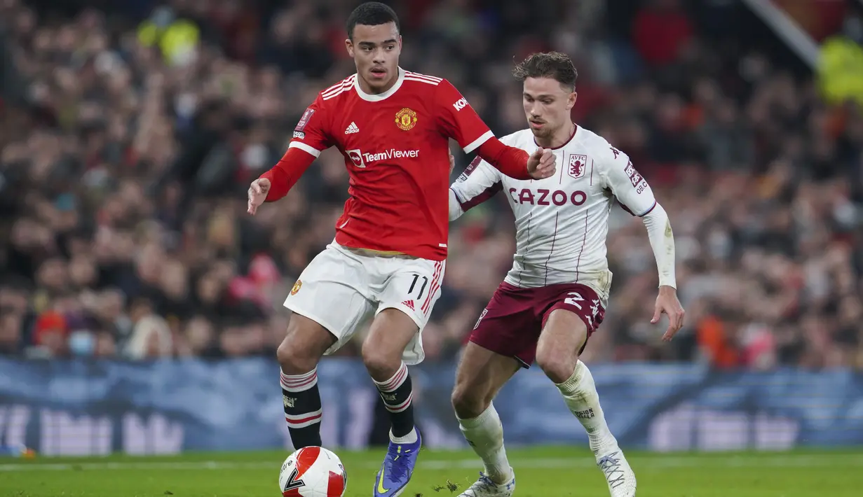 Gelandang Manchester United, Mason Greenwood mengontrol bola dari kawalan gelandang Aston Villa, Matty Cash pada pertandingan putaran ketiga Piala FA di stadion Old Trafford, Inggris, Selasa (11/1/2022). Berkat hasil ini, MU berhak lolos ke putaran keempat. (AP Photo/Jon Super)