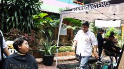 SMA Negeri 70 bekerja sama dengan salah satu barbershop melaksanakan Razia Ganteng untuk memangkas rambut pelajar yang sudah panjang agar terlihat rapih. (Liputan6.com/Herman Zakharia)