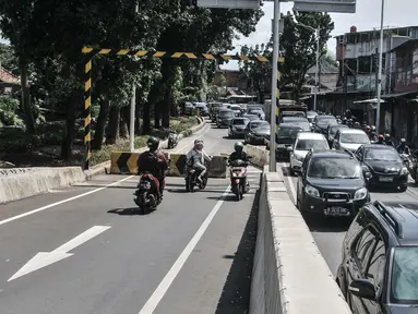 Pengendara motor menerobos separator yang menutup akses jalan layang atau flyover tapal kuda Lenteng Agung, Jakarta, Minggu (28/2/2021). Minimnya pengawasan menyebabkan banyak pengendara sepeda motor nekat menerobos flyover tapal kuda Lenteng Agung yang masih ditutup. (merdeka.com/Iqbal S Nugroho)