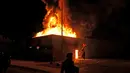 Bendera Amerika jatuh dari tiangnya saat polisi berusaha mengamankan daerah itu setelah pengunjuk rasa membakar gedung di Kenosha, Wisconsin, Amerika Serikat, Senin (24/8/2020). Protes dipicu oleh penembakan Jacob Blake oleh petugas polisi Kenosha sehari sebelumnya. (AP Photo/David Goldman)