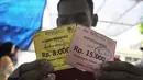Seorang warga memperlihatkan kupon sembako di Rumah Hati Suci, Jakarta, Minggu (21/6/2015). Warga terlihat  antusias membeli barang di pasar murah tersebut. (Liputan6.com/Herman Zakharia)