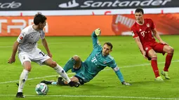 Pemain Borussia Moenchengladbach Jonas Hofmann (kiri) mencoba menembak bola di depan kiper Bayern Munchen Manuel Neuer (tengah) pada pertandingan Bundesliga di Borussia Park, Moenchengladbach, Jerman, Jumat (8/1/2021). Bayern Munchen kalah 2-3. (AP Photo/Martin Meissner, Pool)