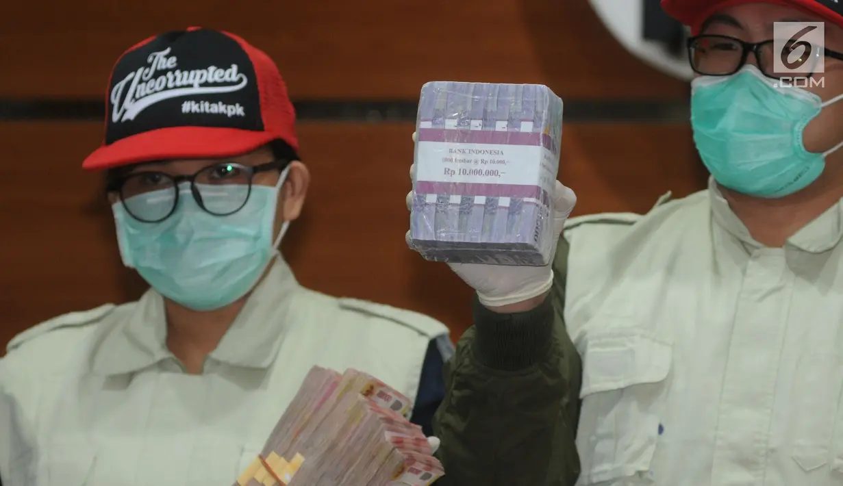 Petugas KPK menunjukkan barang bukti uang hasil OTT Kabupaten Buton Selatan di gedung KPK, Jakarta, Kamis (24/5). KPK juga menyita barang bukti berupa uang sebesar Rp 400 juta terkait dugaan suap proyek Kabupaten Buton Selatan. (Merdeka.com/Dwi Narwoko)