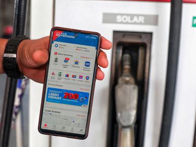 Petugas menunjukan aplikasi mypertamina di salah satu SPBU di Jakarta, Kamis (25/5/2023). (Liputan6.com/Angga Yuniar)