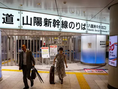 Orang-orang berjalan di depan gerbang tiket yang ditutup untuk Tokaido Shinkansen di Stasiun Tokyo pada 31 Agustus 2024. (Philip FONG/AFP)