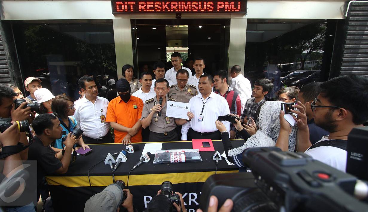 Kabid Humas Polda Metro Jaya Kombes Awi Setiyono menunjukkan barang bukti serta tersangka kasus videotron porno di Prapanca, Kebayoran Baru, berinisal SAR, saat rilis kasus videotron di Polda Metro Jaya, Rabu (5/10). (Liputan6.com/Immanuel Antonius)